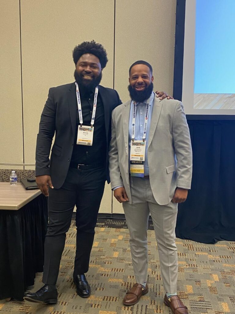 Two men posing at a conference event.